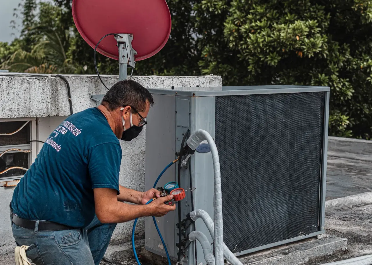 Technician checking an air conditioner with a multimeter