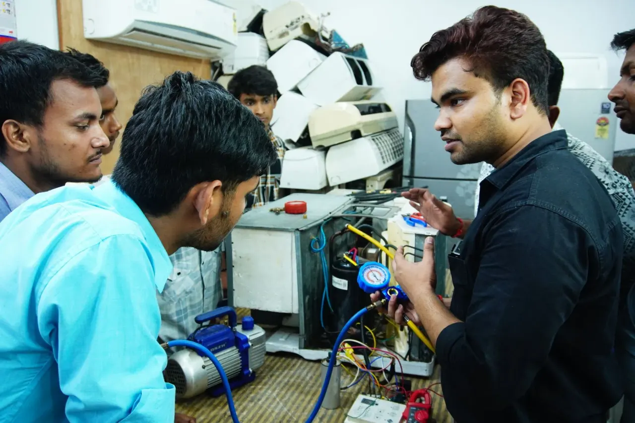 Technicians testing an air conditioner part at a repair workbench